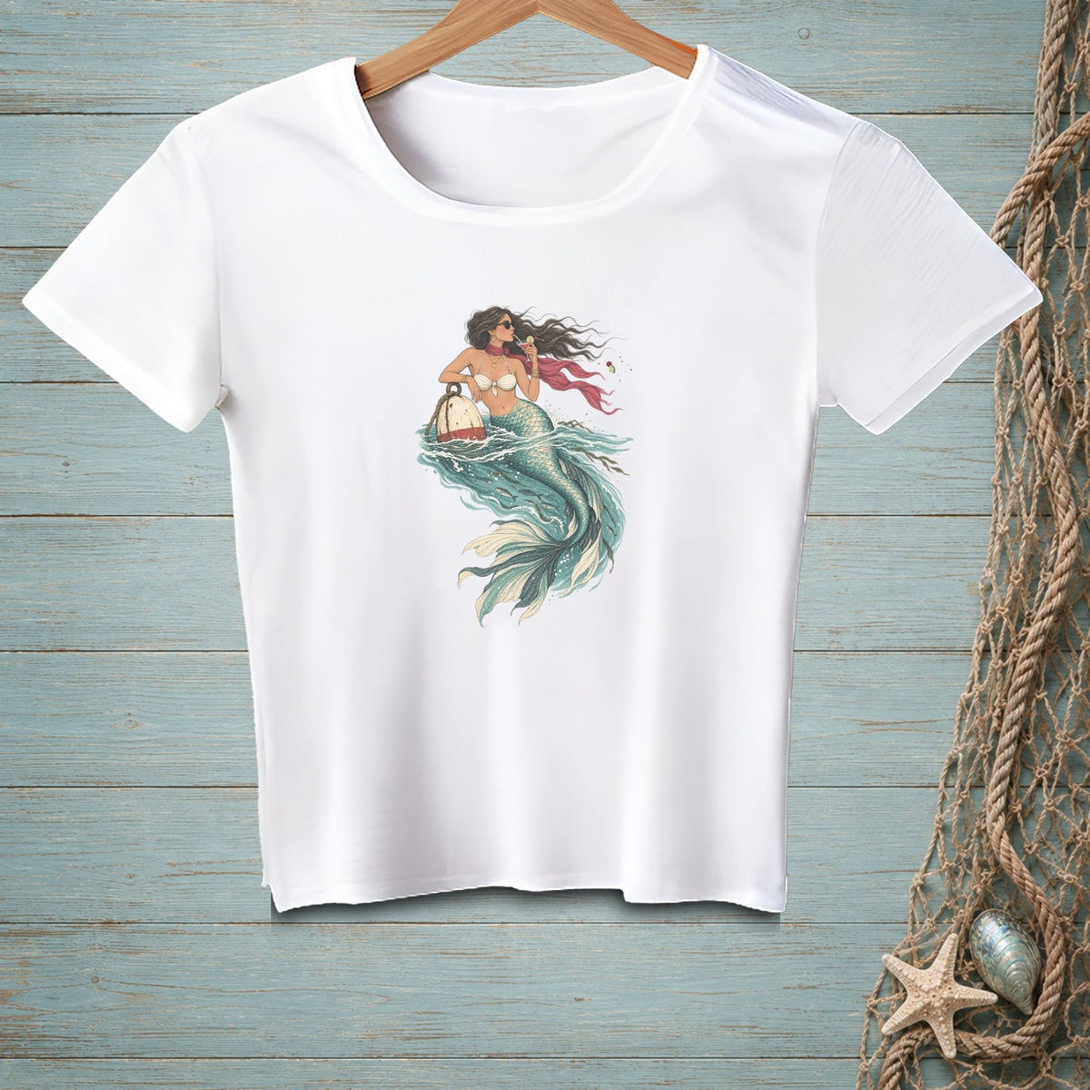 White t-shirt with a graphic of a mermaid in green water holding a buoy.