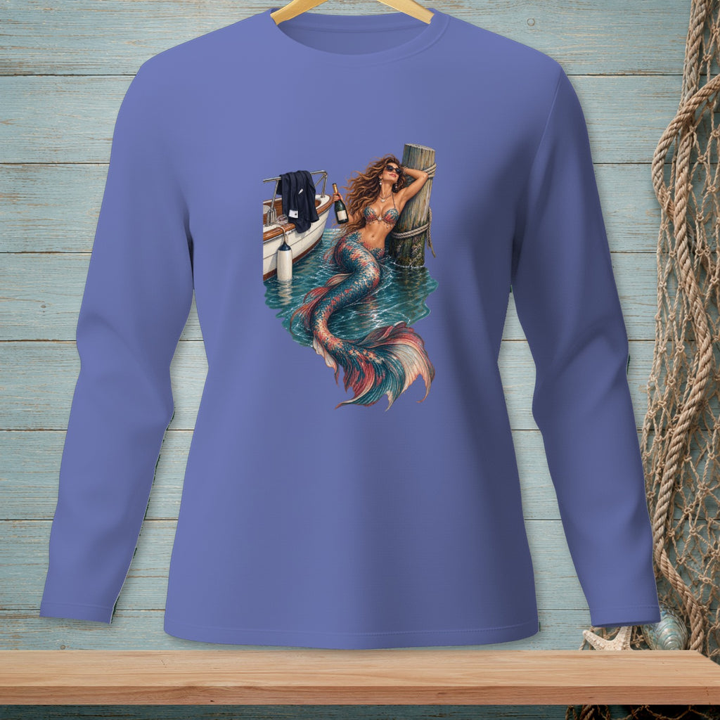 Mermaid with bottle of champagne leans on wooden post near boat.