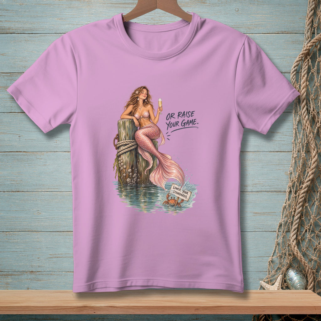 Pink t-shirt with a mermaid holding a drink and text "OR RAISE YOUR GAME."