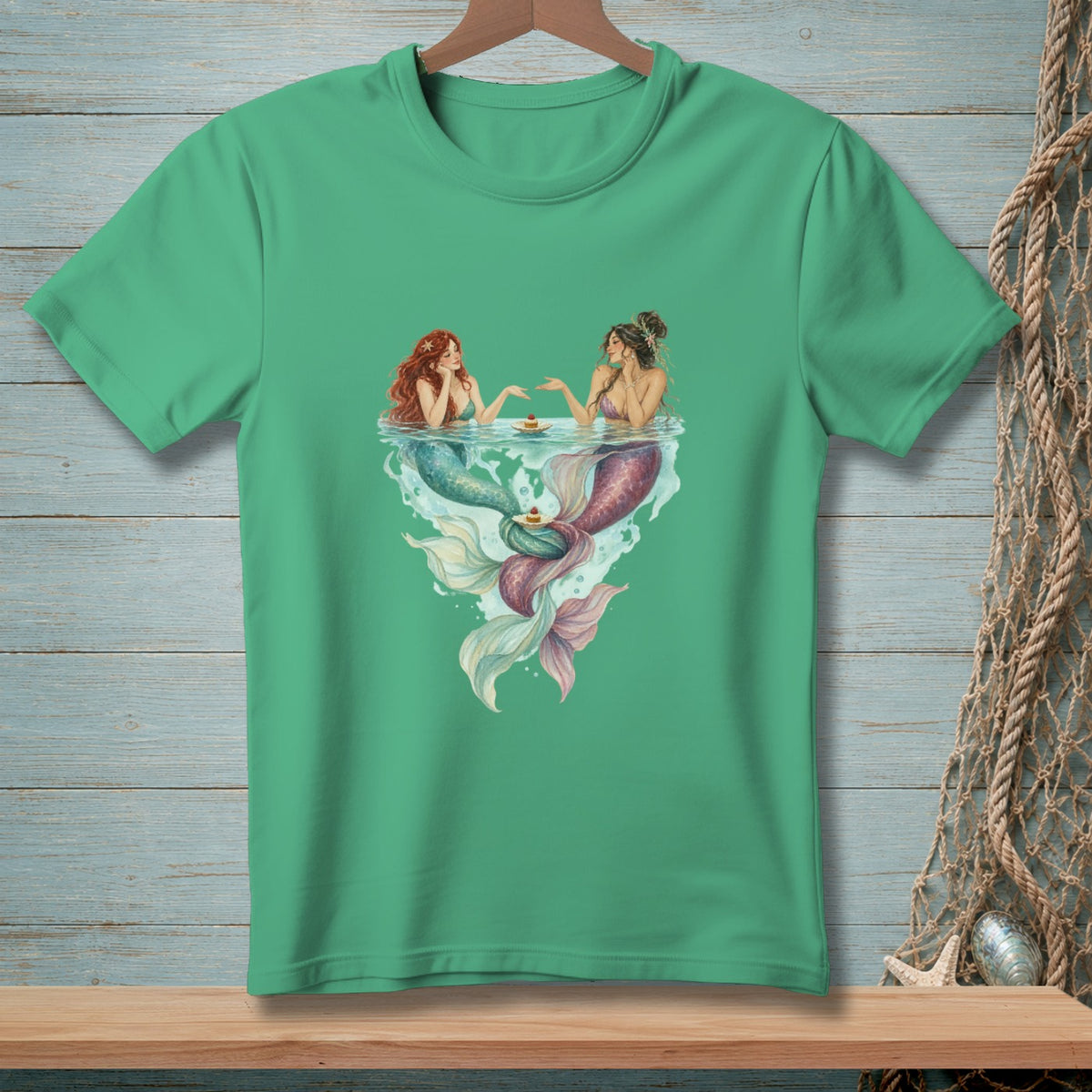 Two mermaids with colorful tails sharing cupcakes in the water.