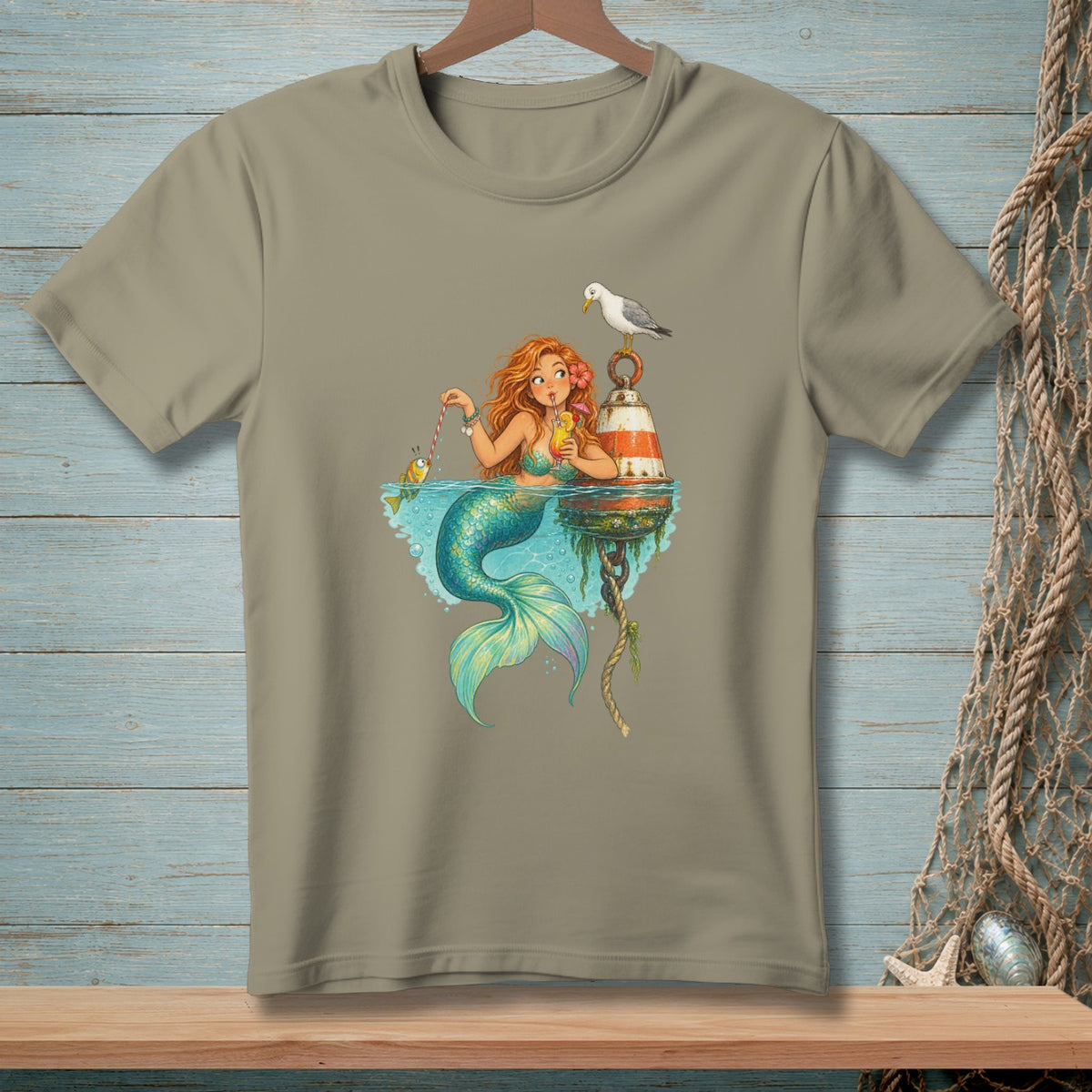 A mermaid holds a drink and fishes near a buoy with a seagull.