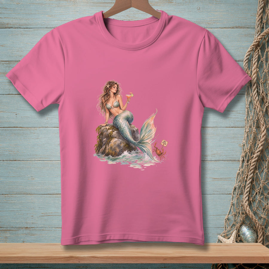 Pink t-shirt with a graphic of a mermaid sitting on a rock holding a drink.