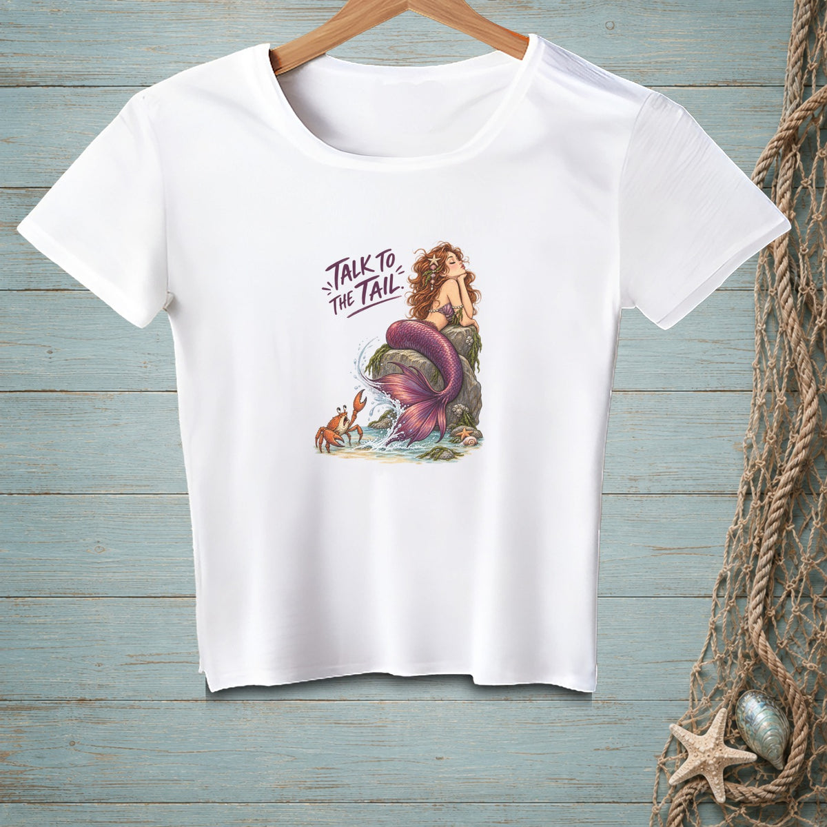 White t-shirt with a graphic of a mermaid, crab, and text "Talk to the Tail".