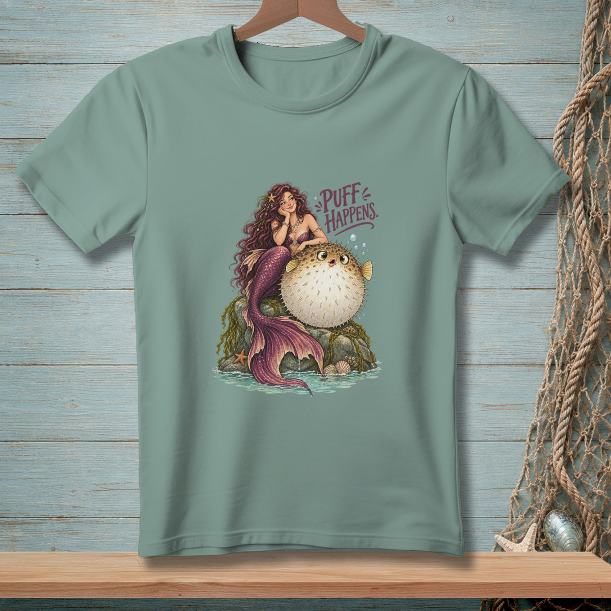 Mermaid with pufferfish and text "PUFF HAPPENS" on a teal t-shirt.
