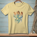 Three mermaids with champagne glasses and tails in blue and green water.