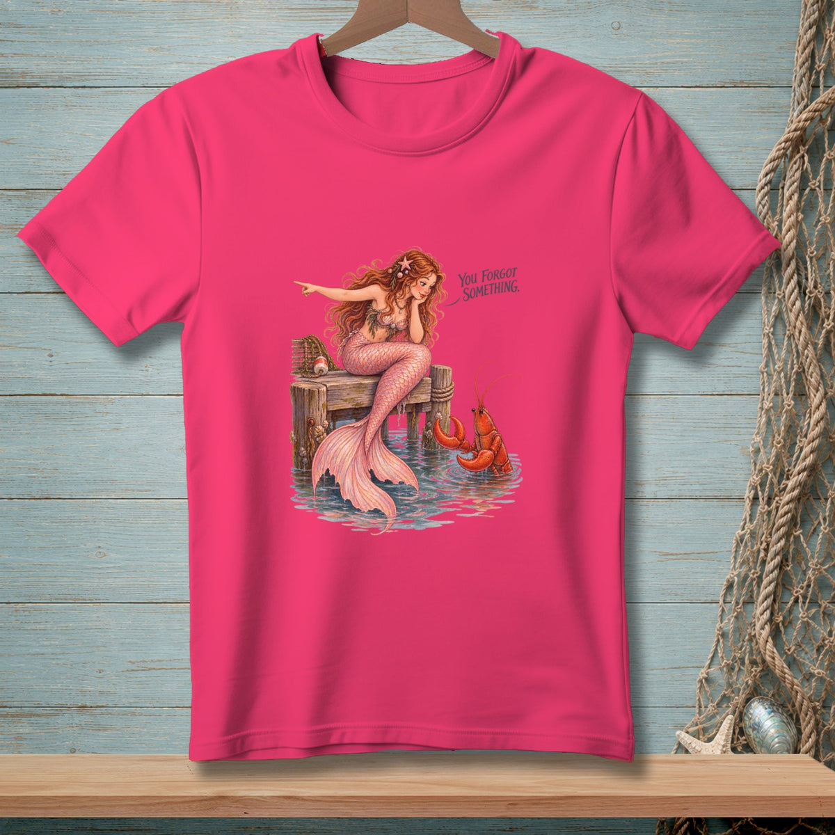 Mermaid sitting on dock with lobster and text "You Forgot Something."