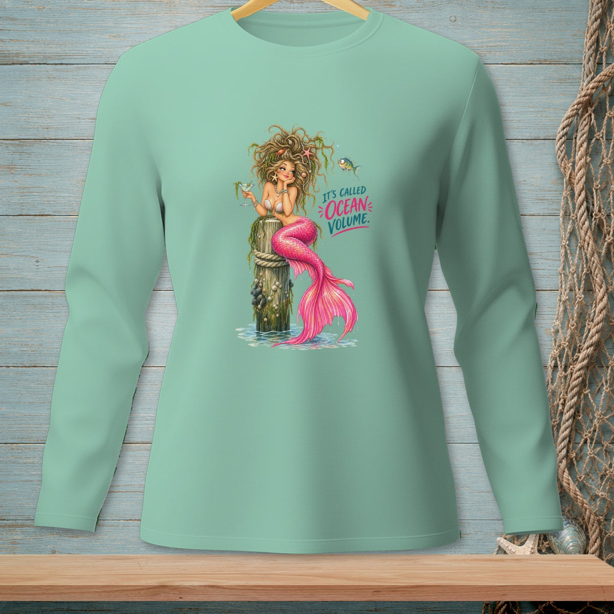 Mermaid holding a drink on a post with "It's Called Ocean Volume" text.