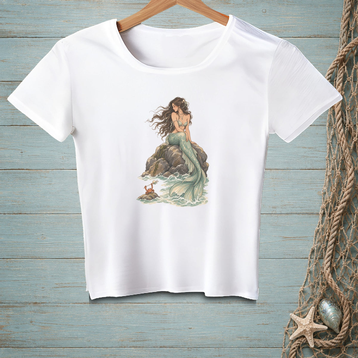 White t-shirt featuring a mermaid on a rock with a crab and ocean waves.