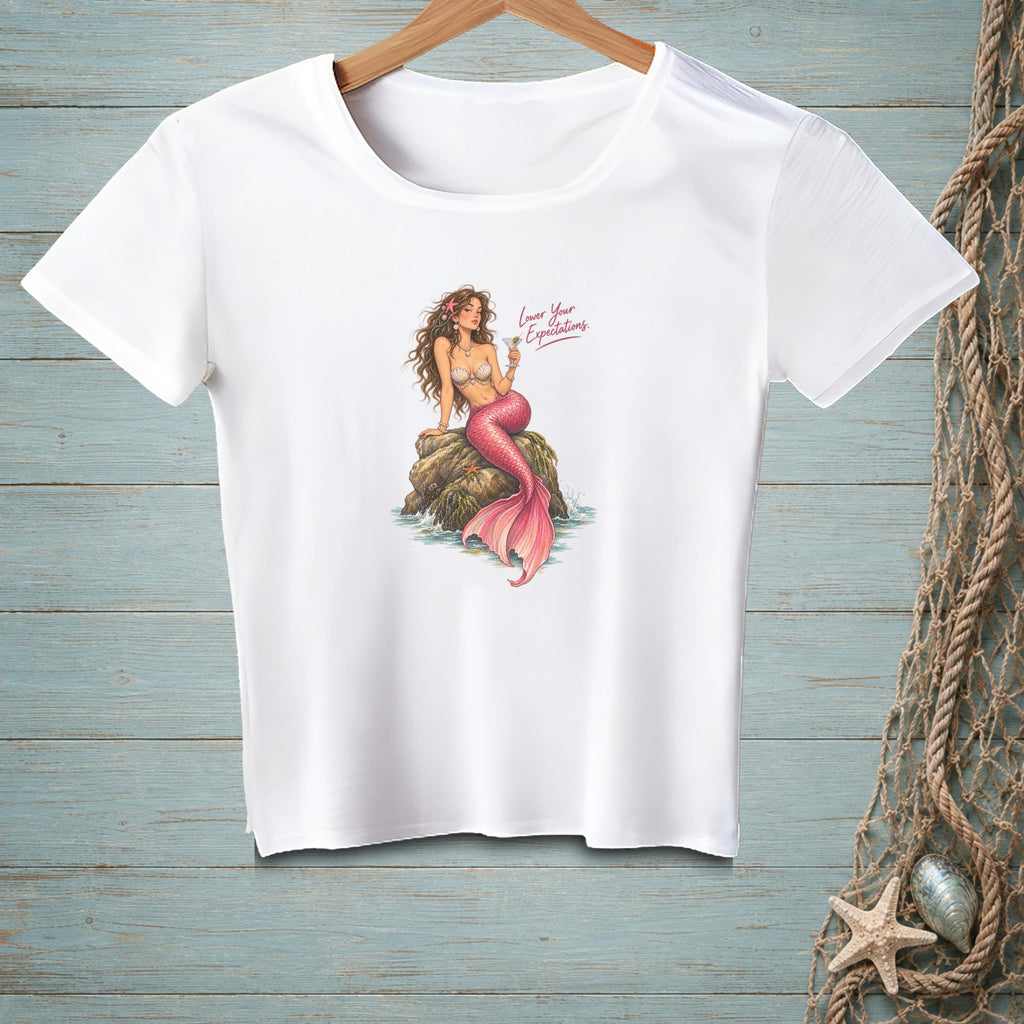 White t-shirt featuring a mermaid sitting on a rock with "Lower Your Expectations" text.