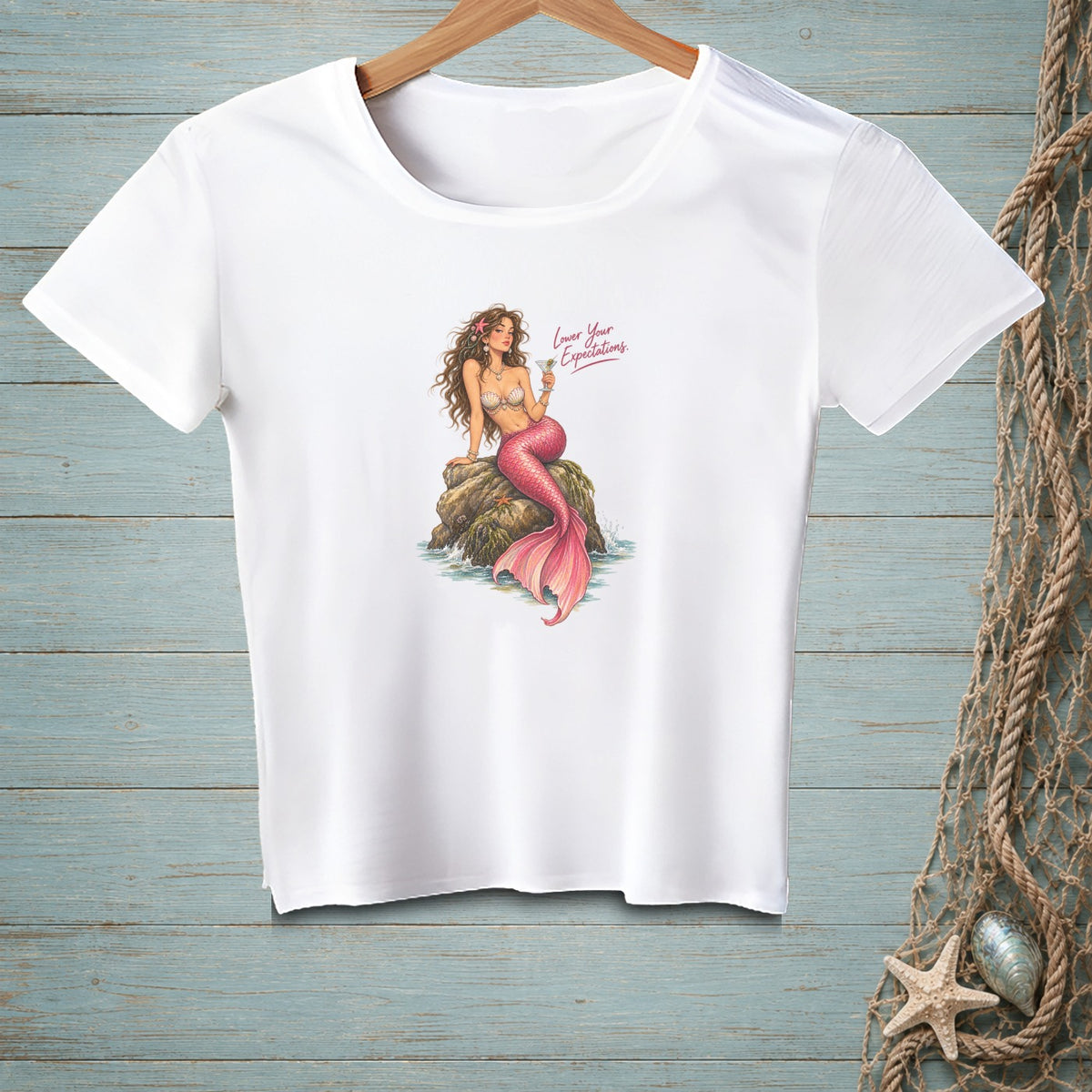 White t-shirt featuring a mermaid sitting on a rock with "Lower Your Expectations" text.
