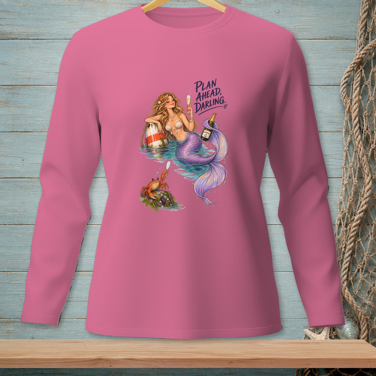 Pink long sleeve shirt with a mermaid, crab, champagne, and the text "PLAN AHEAD, DARLING."