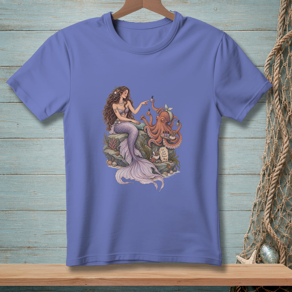 Mermaid with octopus getting a manicure on a rock with seashells and seaweed.
