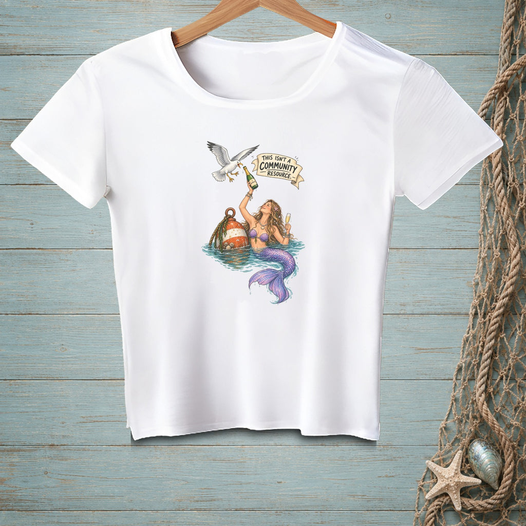 Mermaid with champagne, seagull, and text "THIS ISN'T A COMMUNITY RESOURCE" on a white shirt.