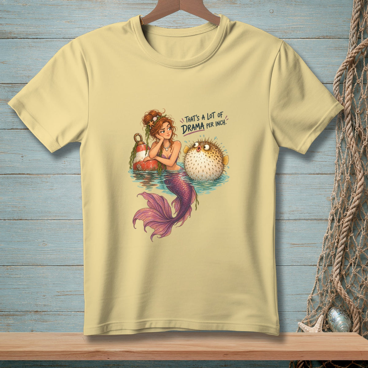 Mermaid with pufferfish on yellow t-shirt, text reads "That's a lot of drama per inch."