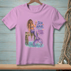 Lilac t-shirt with mermaid illustration and "Sea Hair Zero Care" text.