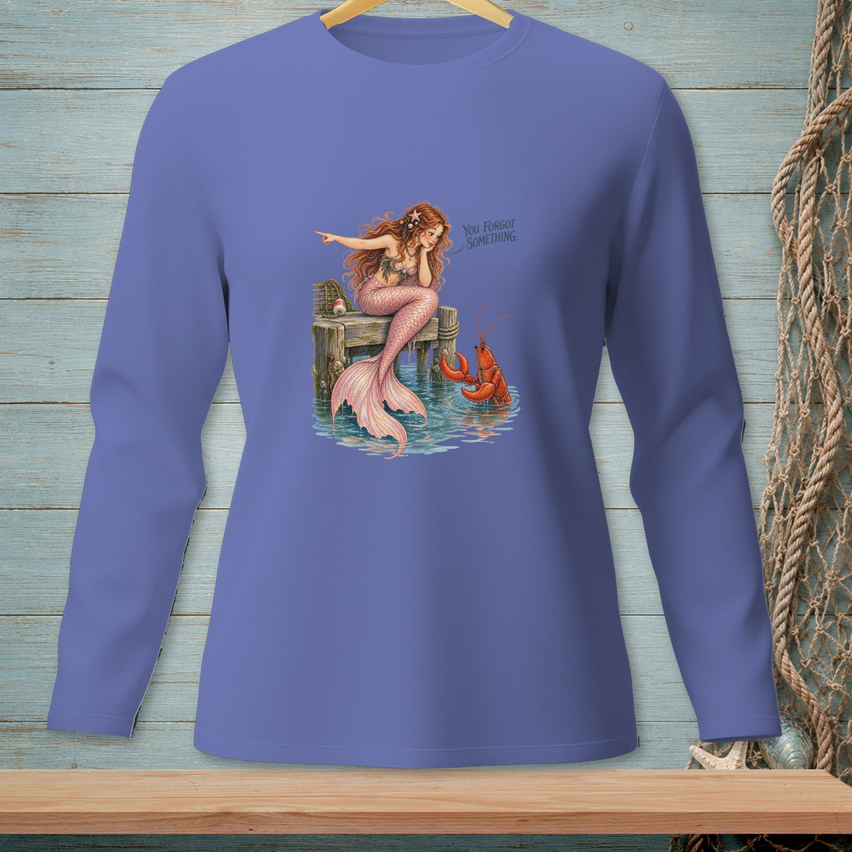 Mermaid sitting on a dock pointing at a lobster, with text "You forgot something."