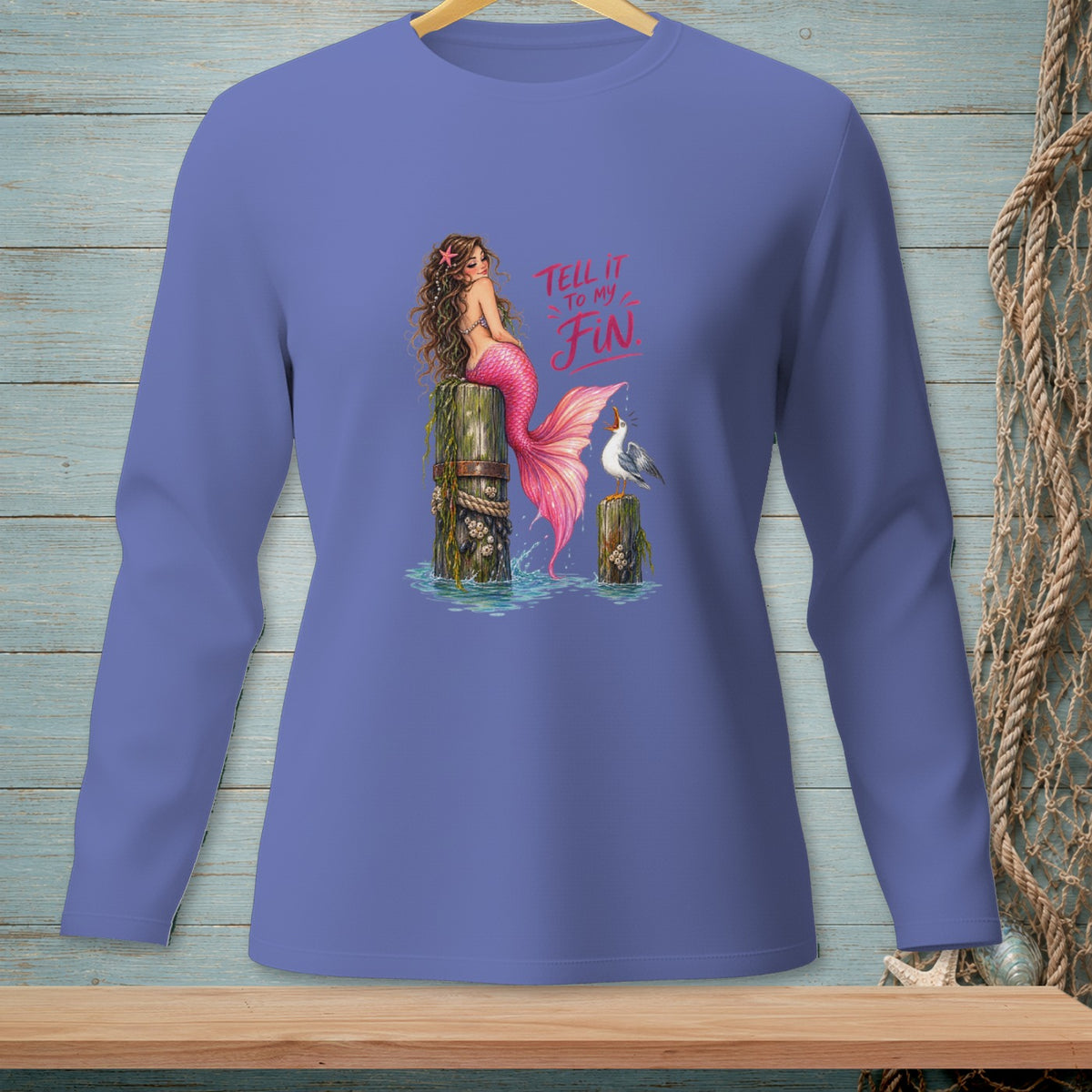 Mermaid with pink tail sits on a pier next to a seagull.