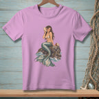 Lavender t-shirt with a mermaid sitting on rocks, holding a seashell to her ear.