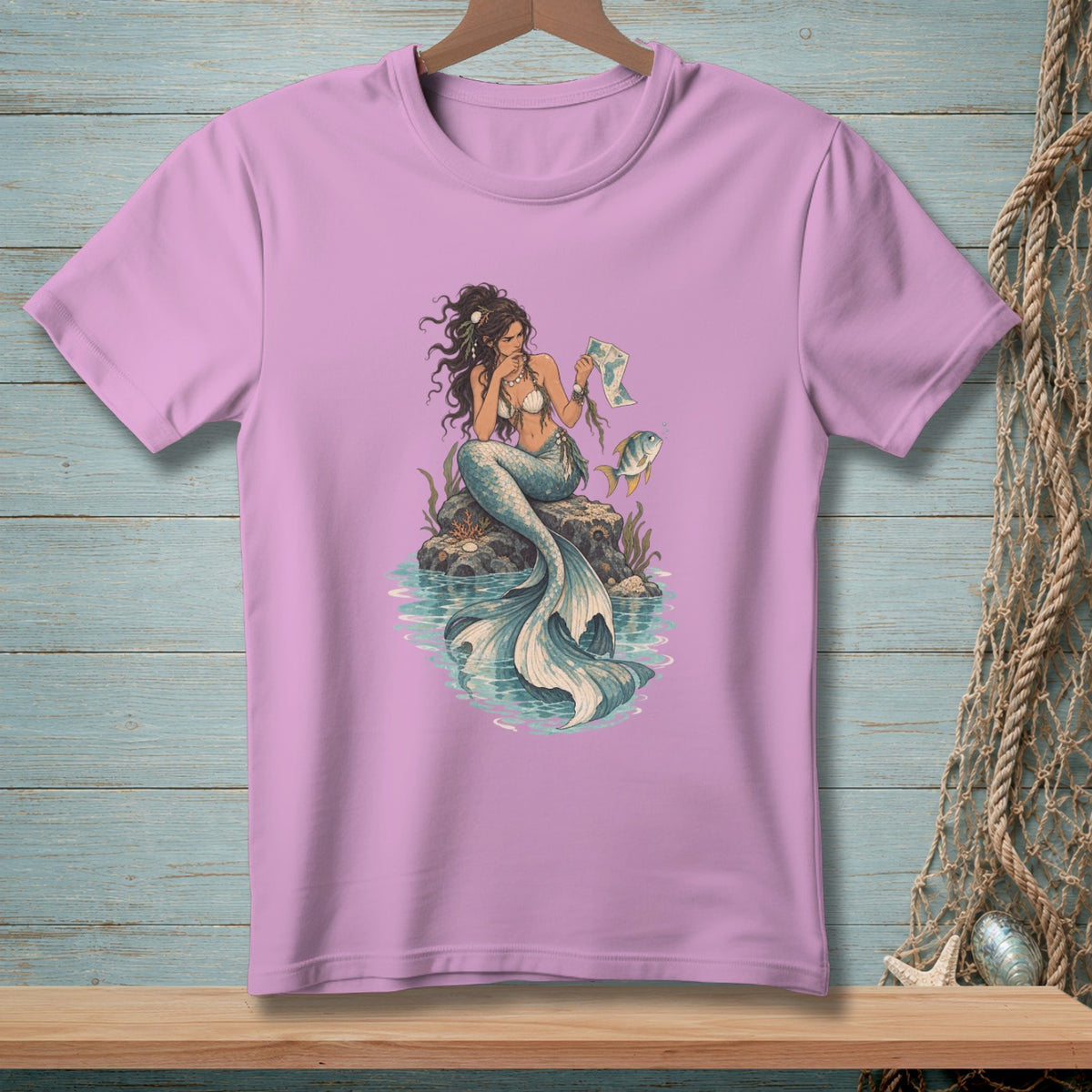 Mermaid sitting on a rock holding a map with a fish nearby.