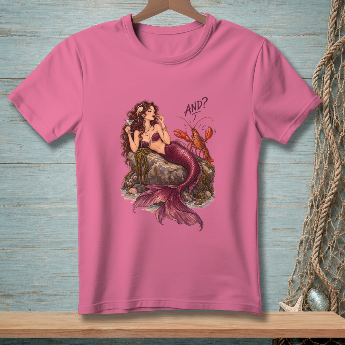 Pink t-shirt with a mermaid and lobster graphic that says "AND?".