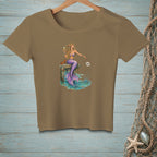 Mermaid with purple tail, holding champagne, sits on dock with crab.