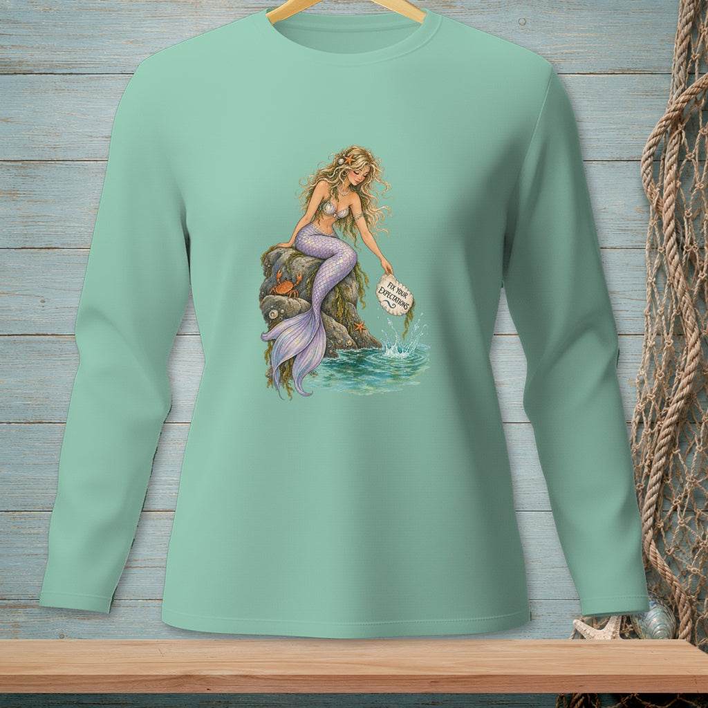 Mermaid with purple tail on a rock dropping a message in a bottle that says "Fix Your Expectations."