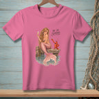 Pink t-shirt with illustration of a mermaid and lobster on a dock, text "Be So Serious."