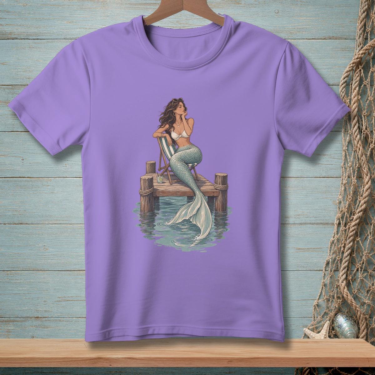 Purple t-shirt with illustration of a mermaid on a dock.