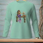 Mermaid with crab holding a fan on a wooden pier graphic on a light green long-sleeved shirt.