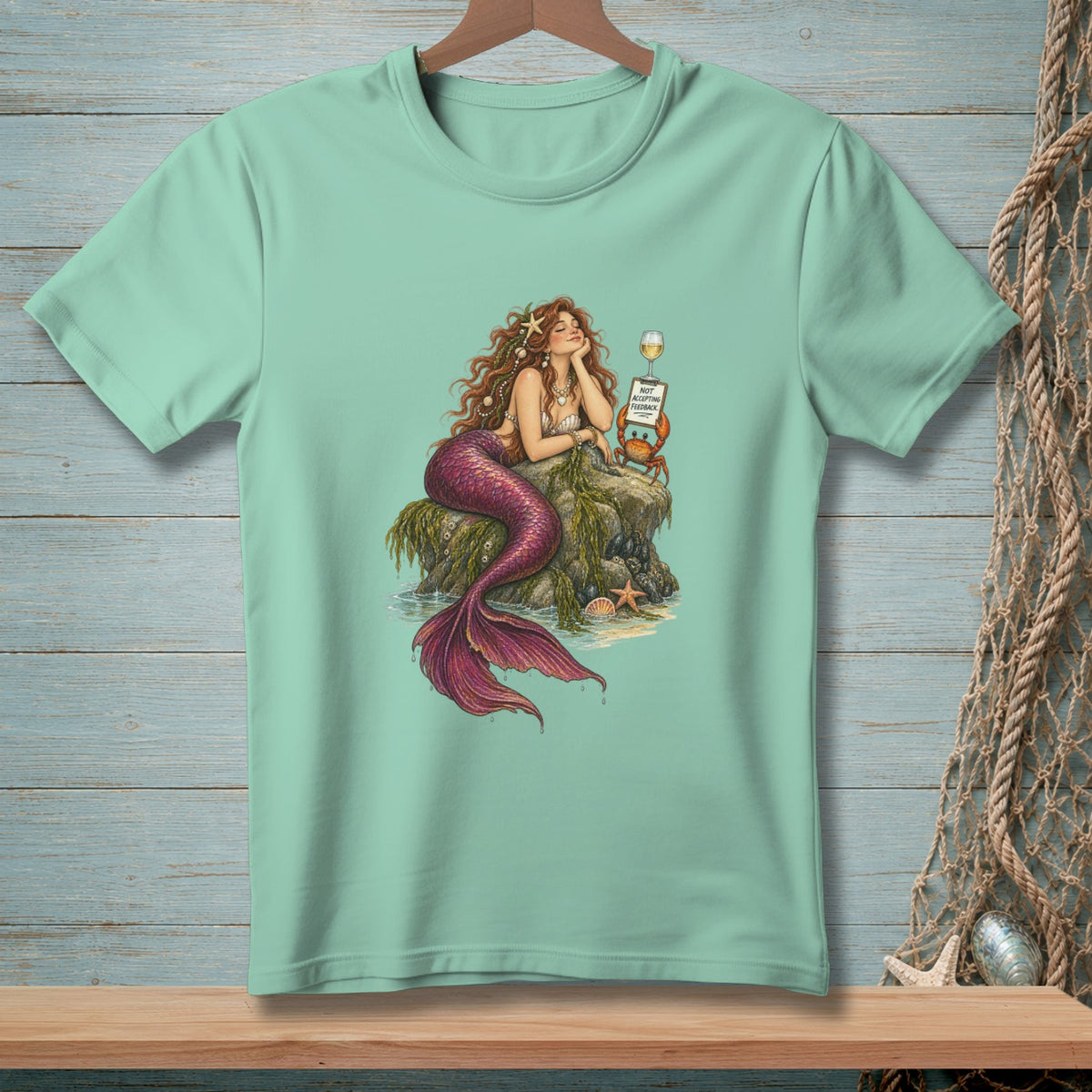 Mermaid on rock with crab holding sign "NOT ACCEPTING FEEDBACK" and a glass of wine.