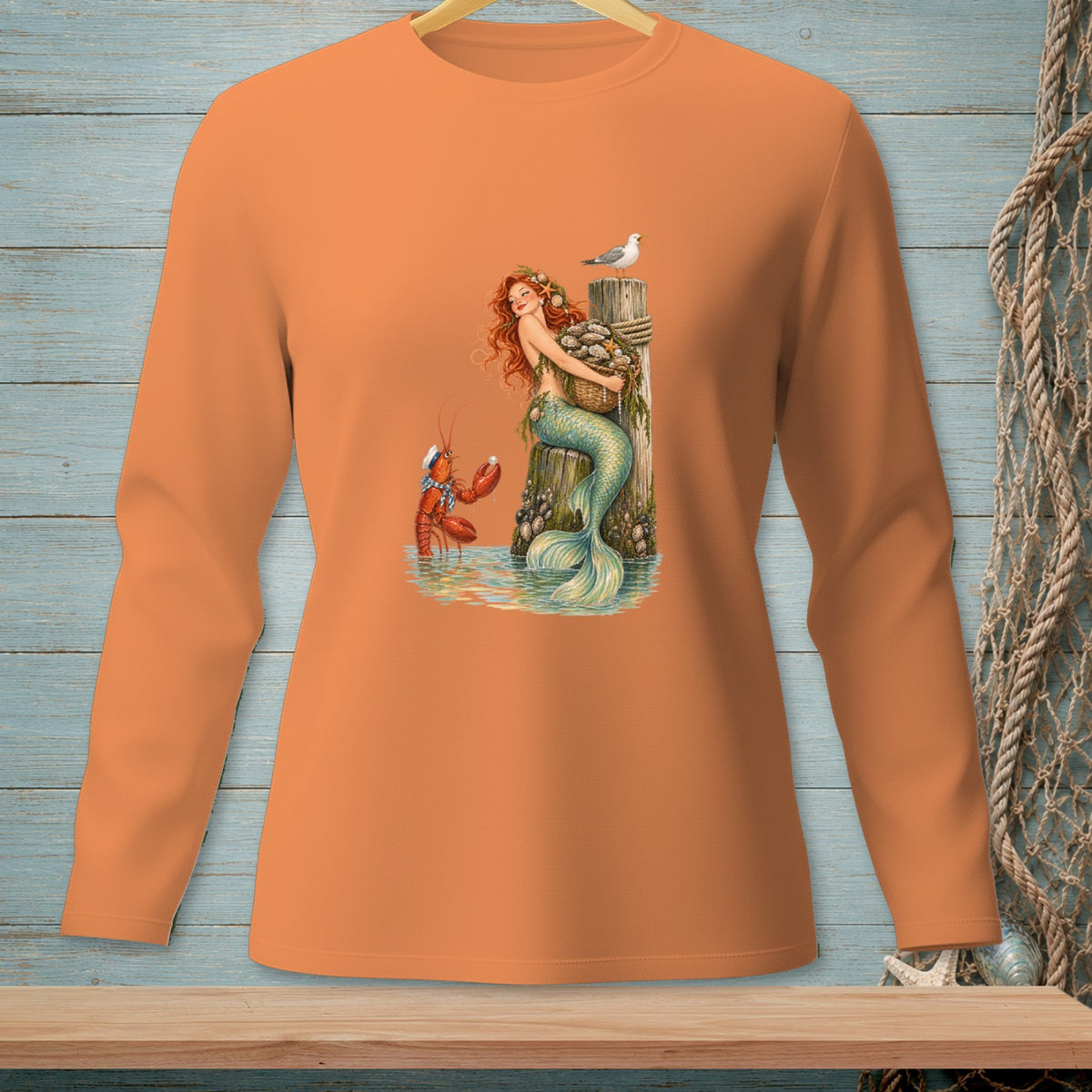 Long-sleeved orange shirt with a mermaid, lobster, and seagull graphic.