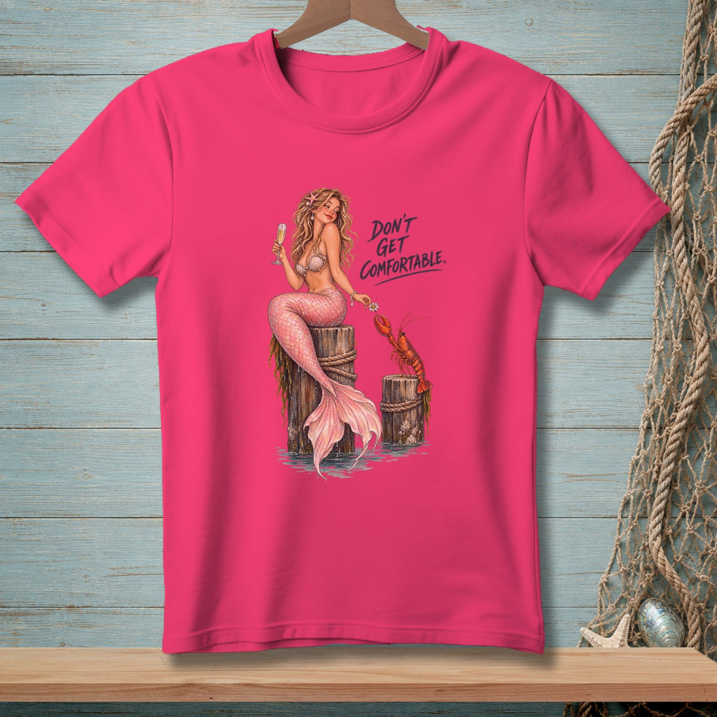 Mermaid and lobster graphic with text "DON'T GET COMFORTABLE." on a pink t-shirt.