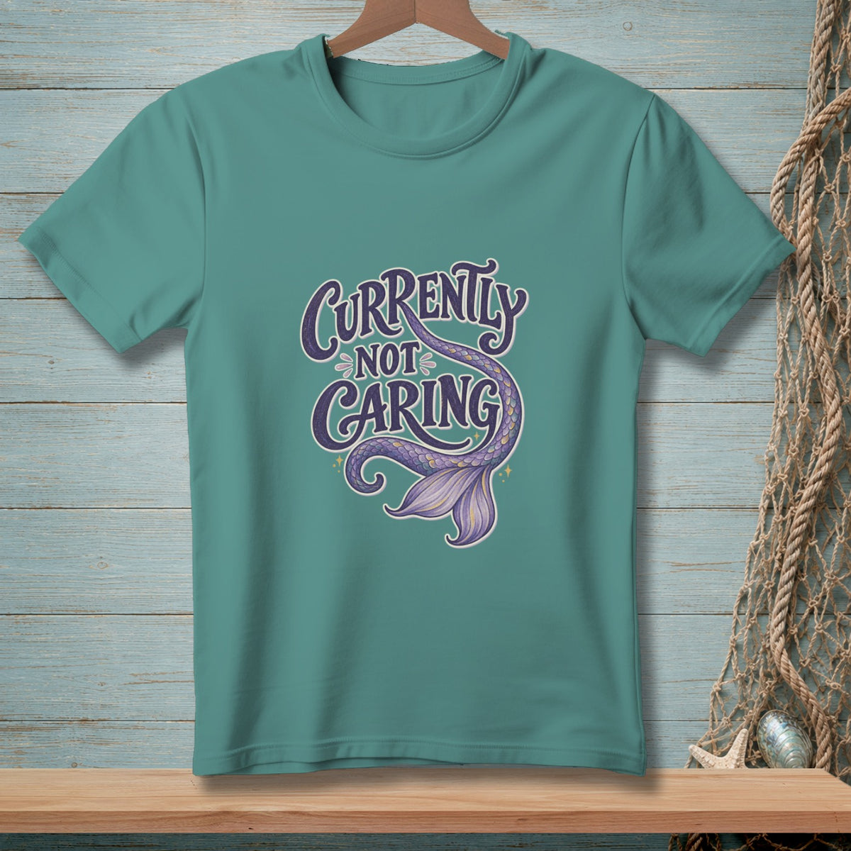 Teal t-shirt with "Currently Not Caring" text and a purple mermaid tail.