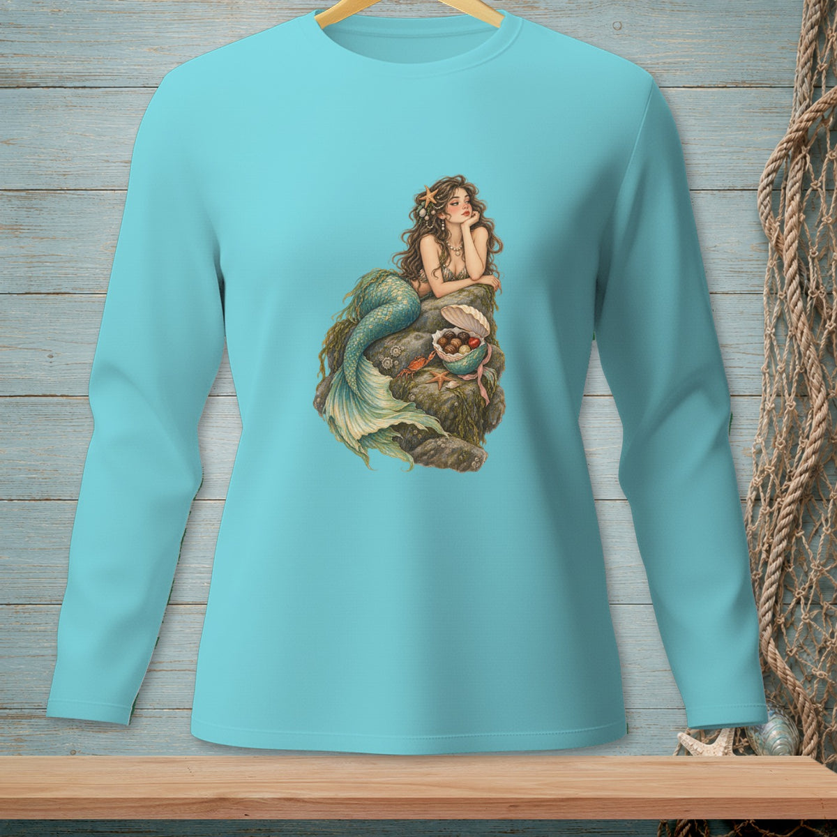 Mermaid with green tail sitting on rocks with shells, pearls, and starfish.