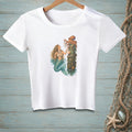 White t-shirt with a mermaid and octopus illustration on a wooden post.