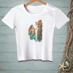 White t-shirt with a mermaid and octopus illustration on a wooden post.