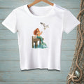 White t-shirt with a mermaid and seagull graphic on a wooden dock.