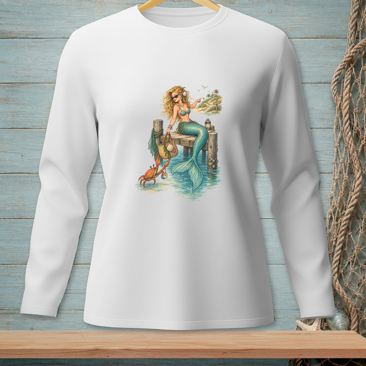 White long-sleeve shirt with a graphic of a mermaid and crab on a pier.