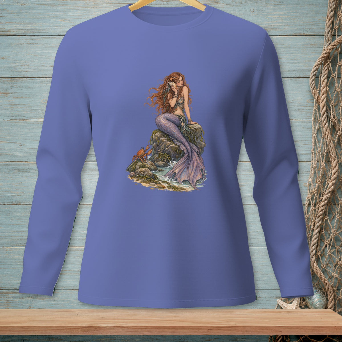 Long-sleeved purple shirt with a mermaid sitting on rocks, holding a seashell.