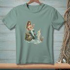 Mermaid on rock with cocktail and crab holding "Be Nice" sign.