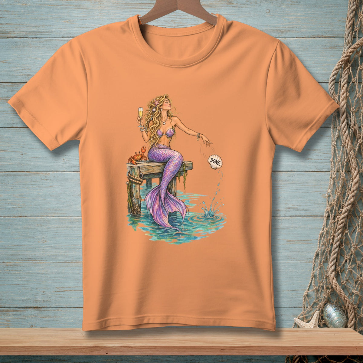 Mermaid with champagne and crab on pier, splashing water, with "DONE" in a seashell.
