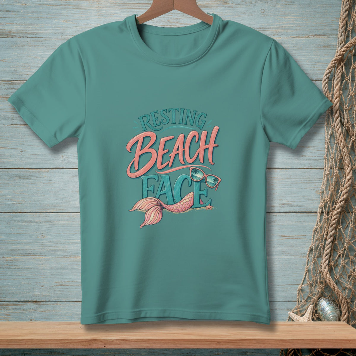 Teal t-shirt with "Resting Beach Face" design featuring a mermaid tail and sunglasses.