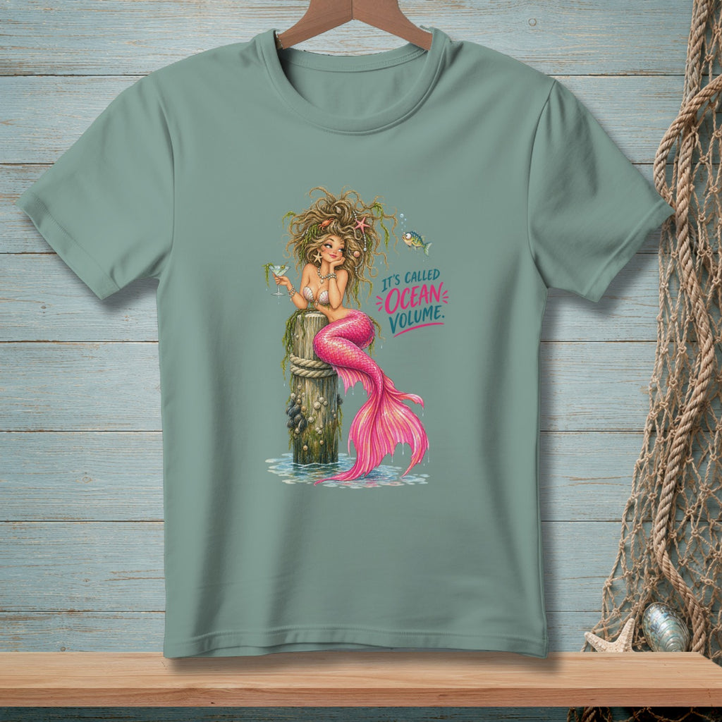 Mermaid sitting on a wooden post with a drink, text reads "It's called Ocean Volume".