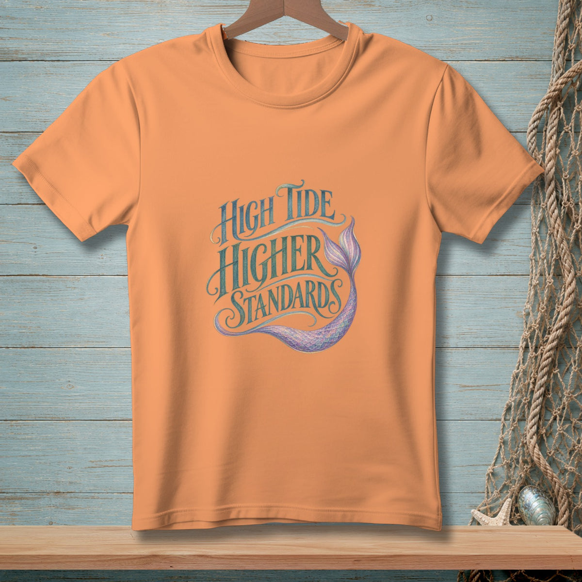 Peach t-shirt with "High Tide Higher Standards" text and mermaid tail graphic.