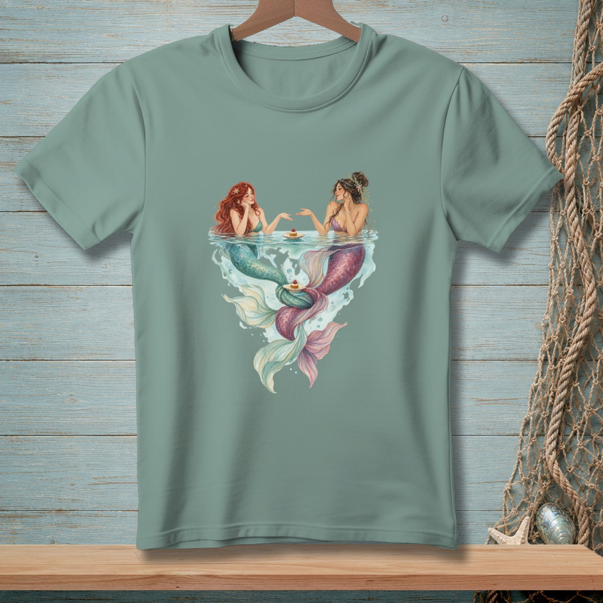 Two mermaids with colorful tails enjoy desserts in the water.