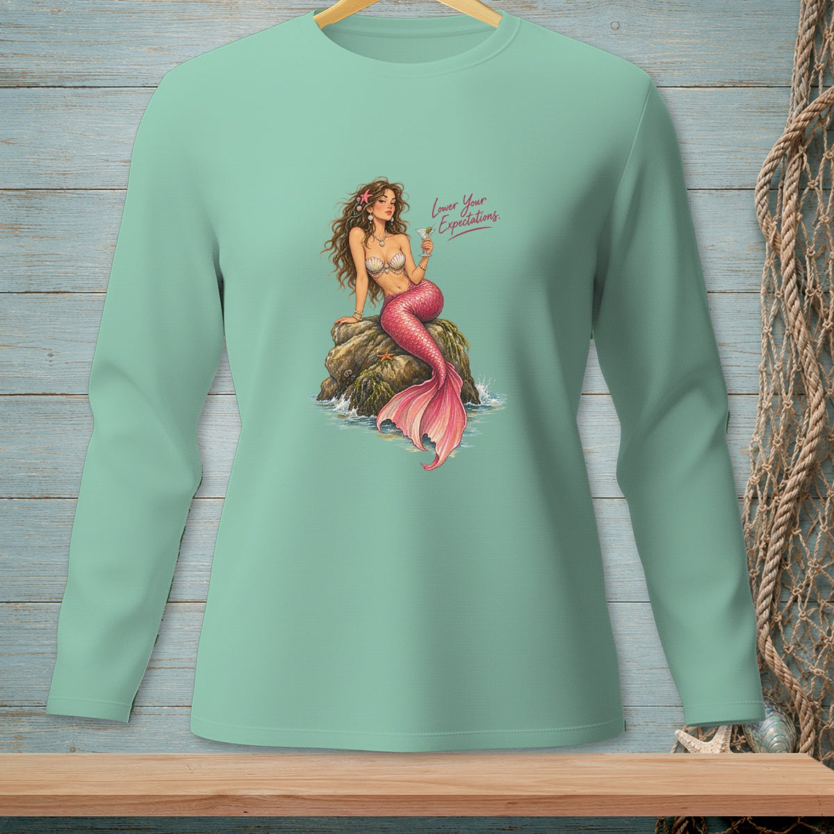 Mint green long sleeve shirt with a mermaid graphic and text "Lower Your Expectations."