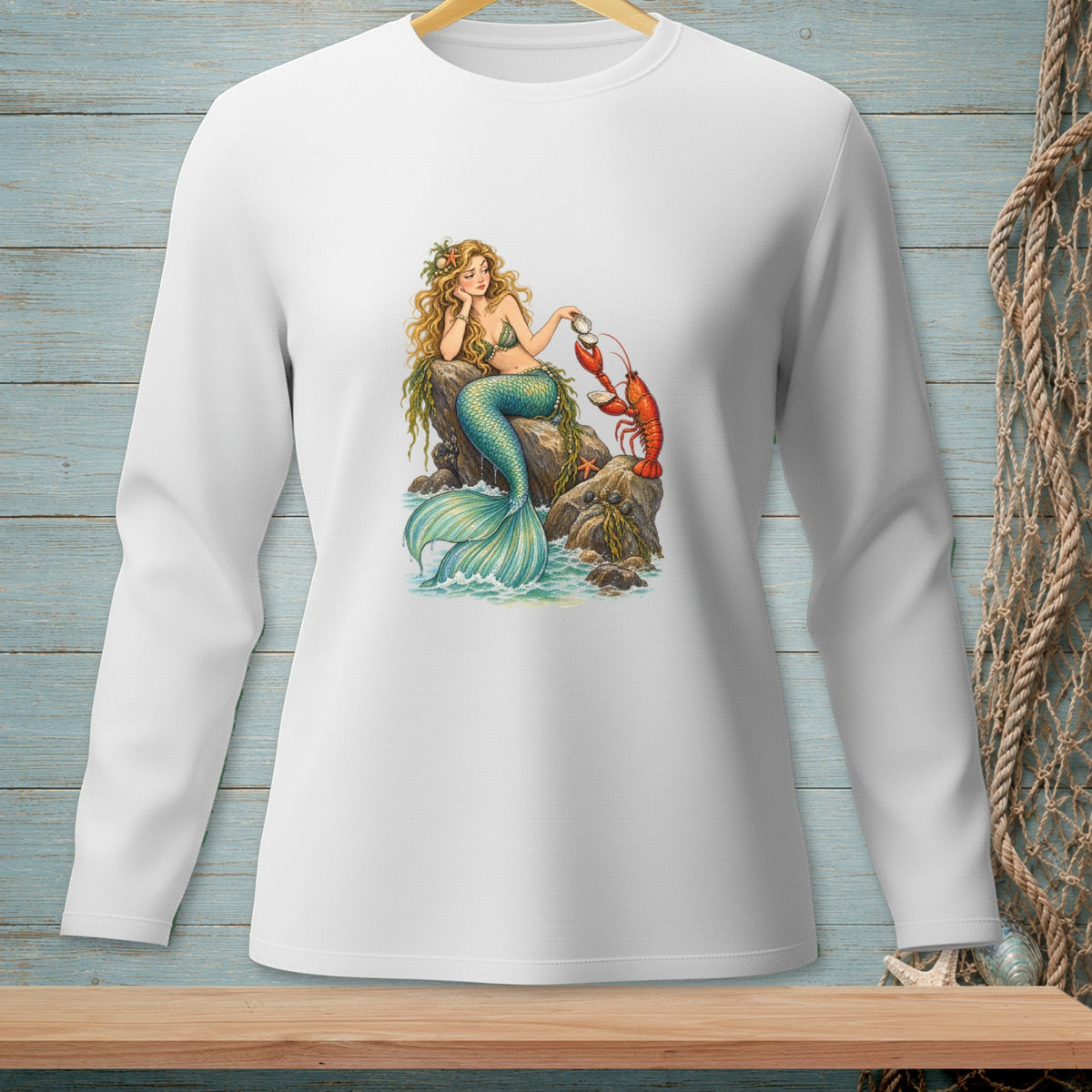 White long-sleeve shirt with a graphic of a mermaid interacting with a lobster on rocks.