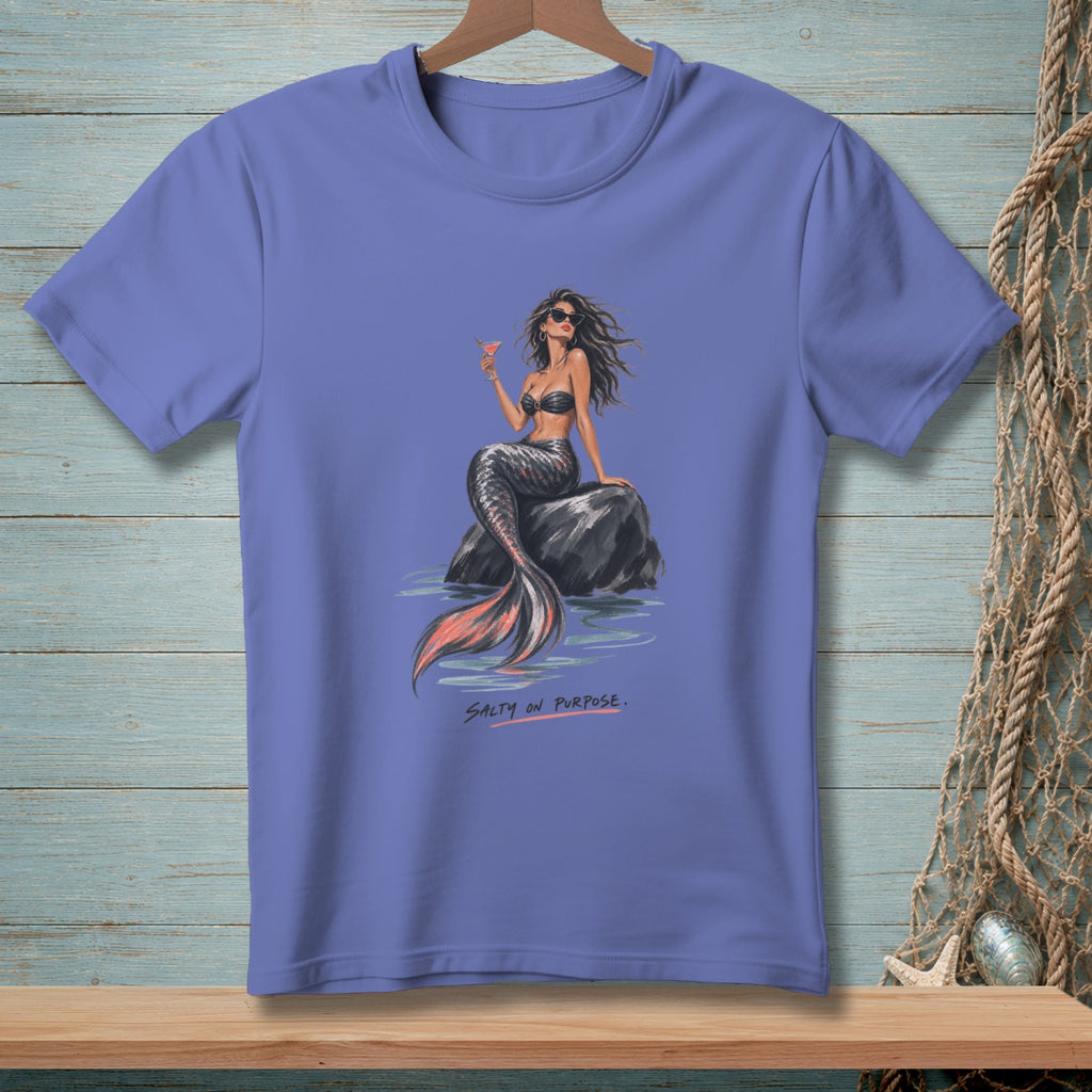 Purple t-shirt with illustration of a mermaid sitting on a rock holding a cocktail.