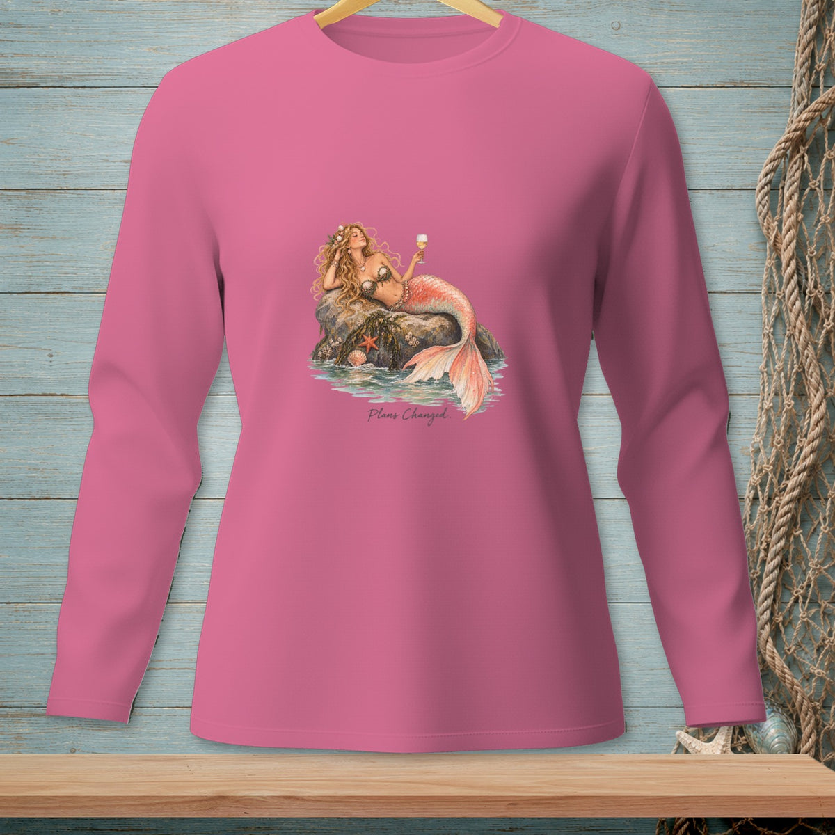 Pink long-sleeve shirt with a graphic of a mermaid holding a drink, with text "Plans Changed."