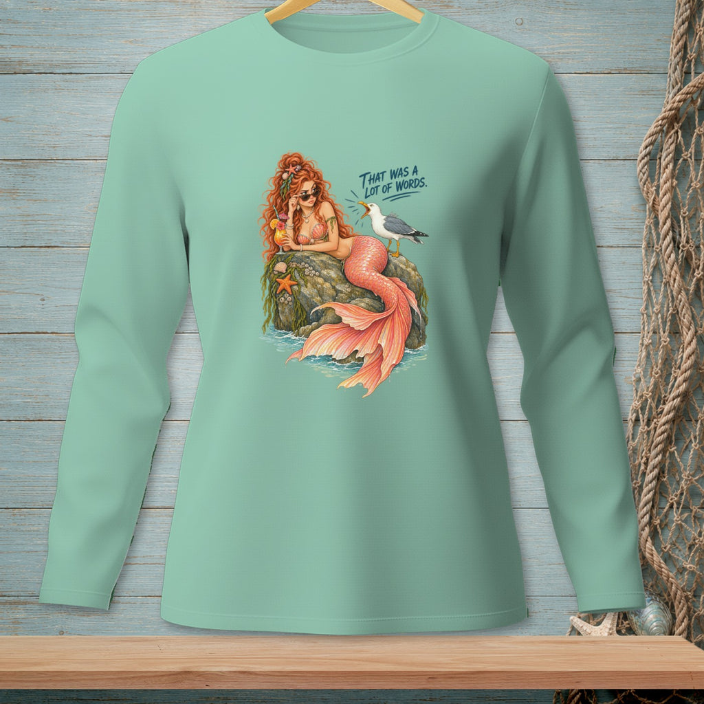 Mermaid with coral tail sits on a rock, holding a drink, near a seagull.
